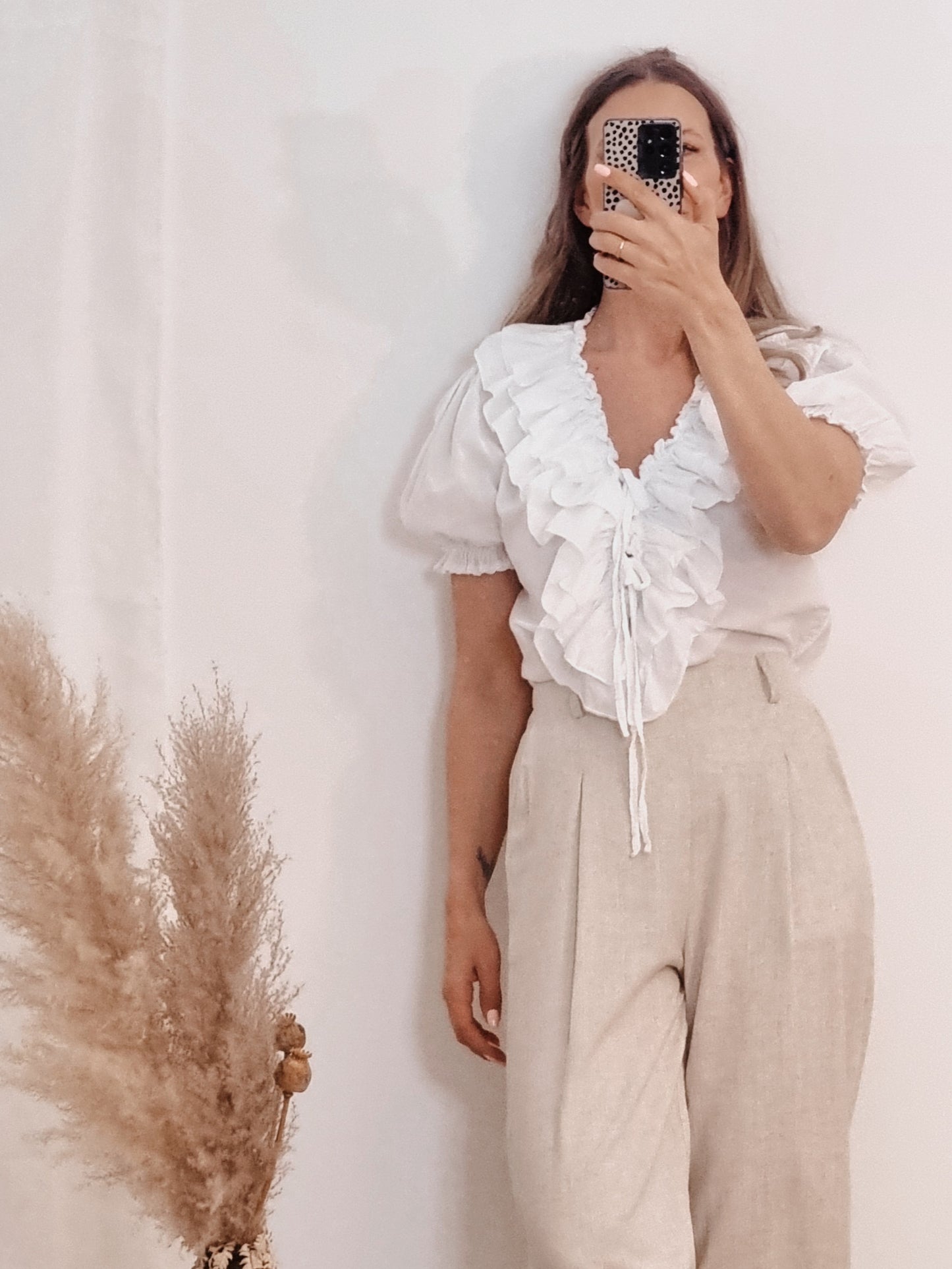 Weiße Bluse mit Rüschenverzierung und Bindebändchen