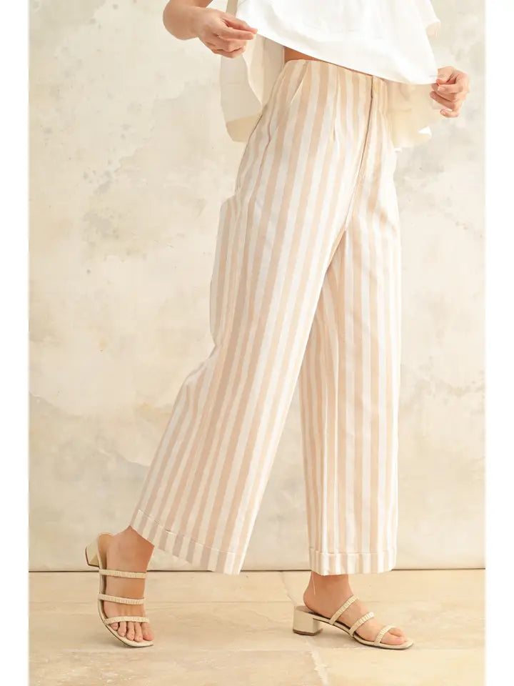 Modell trägt gestreifte Leinenhose mit lockerem Sitz und Sandalen