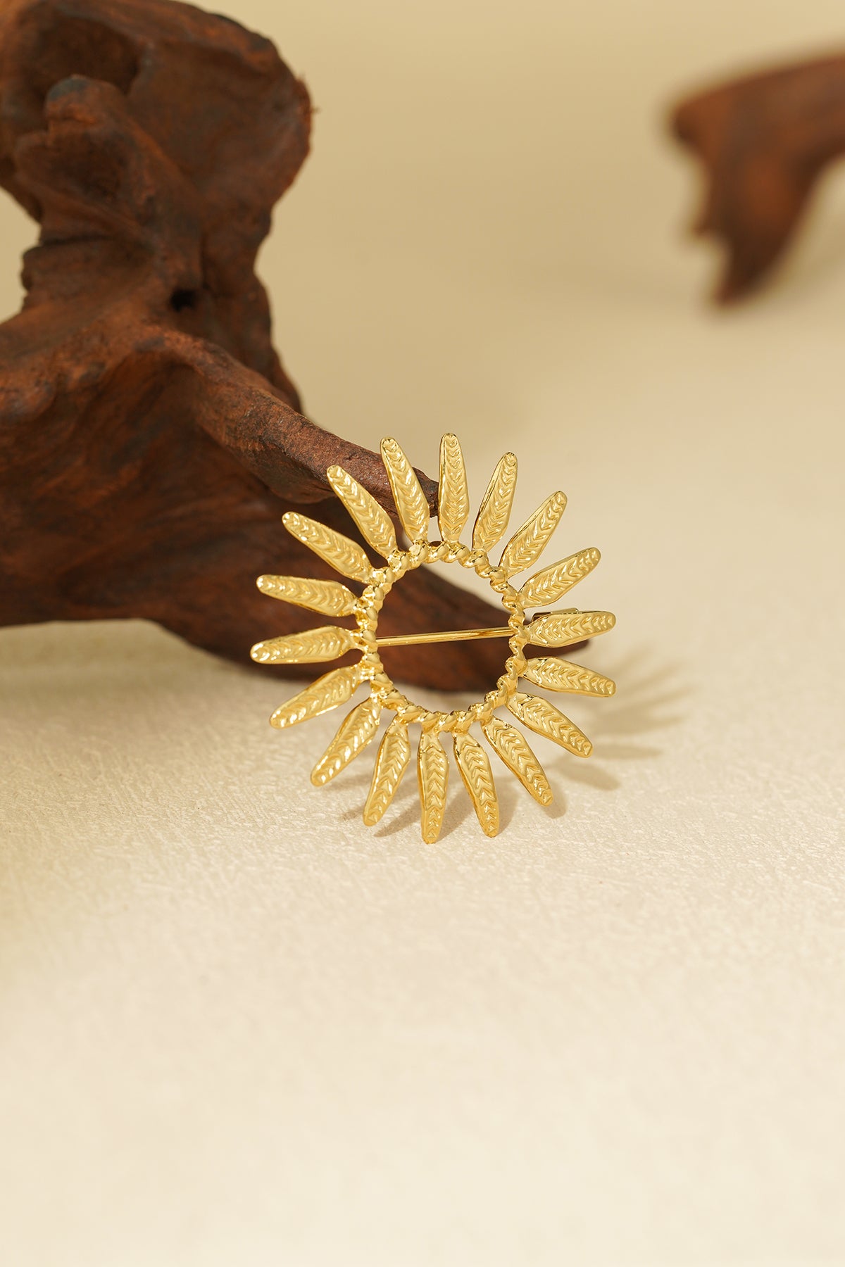 Goldene Sonnenbrosche – warmes Design mit funkelnden Strahlen