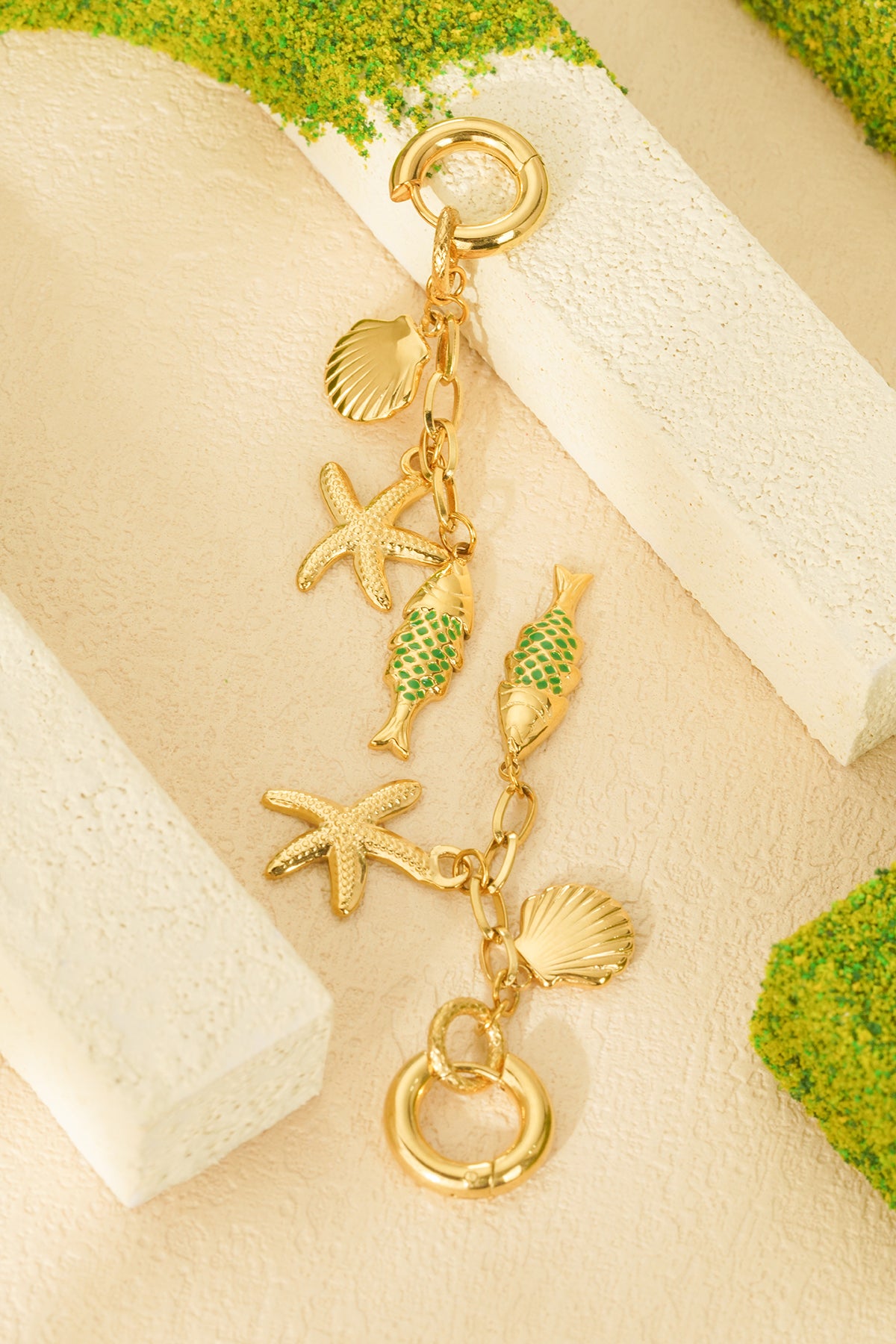 Detailaufnahme der Charm-Ohrringe "In The Ocean" aus Edelstahl mit Muschel-, Seestern- und Fisch-Charm
