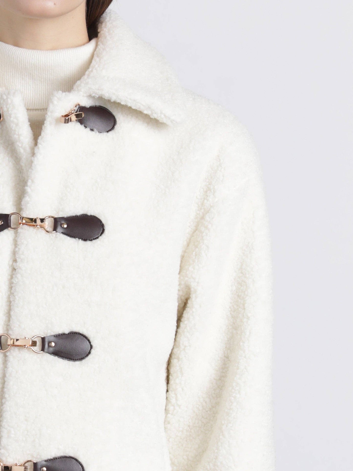 Detailansicht der cremefarbenen Teddyjacke mit strukturiertem Stoff und Knebelverschluss