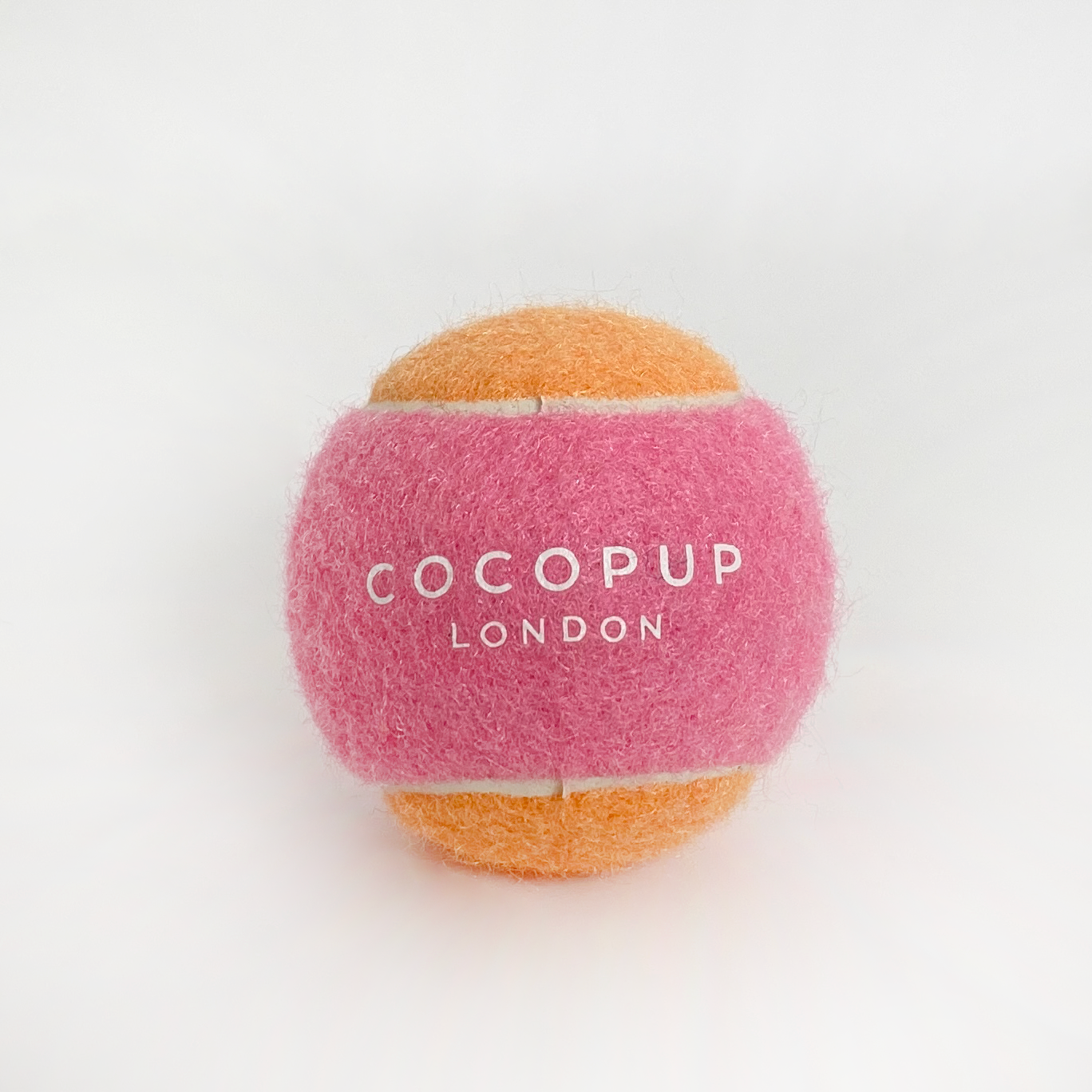 Der COCOPUP Tennisball in Pink und Orange – das perfekte Spielzeug für fröhliche Apportier-Action.