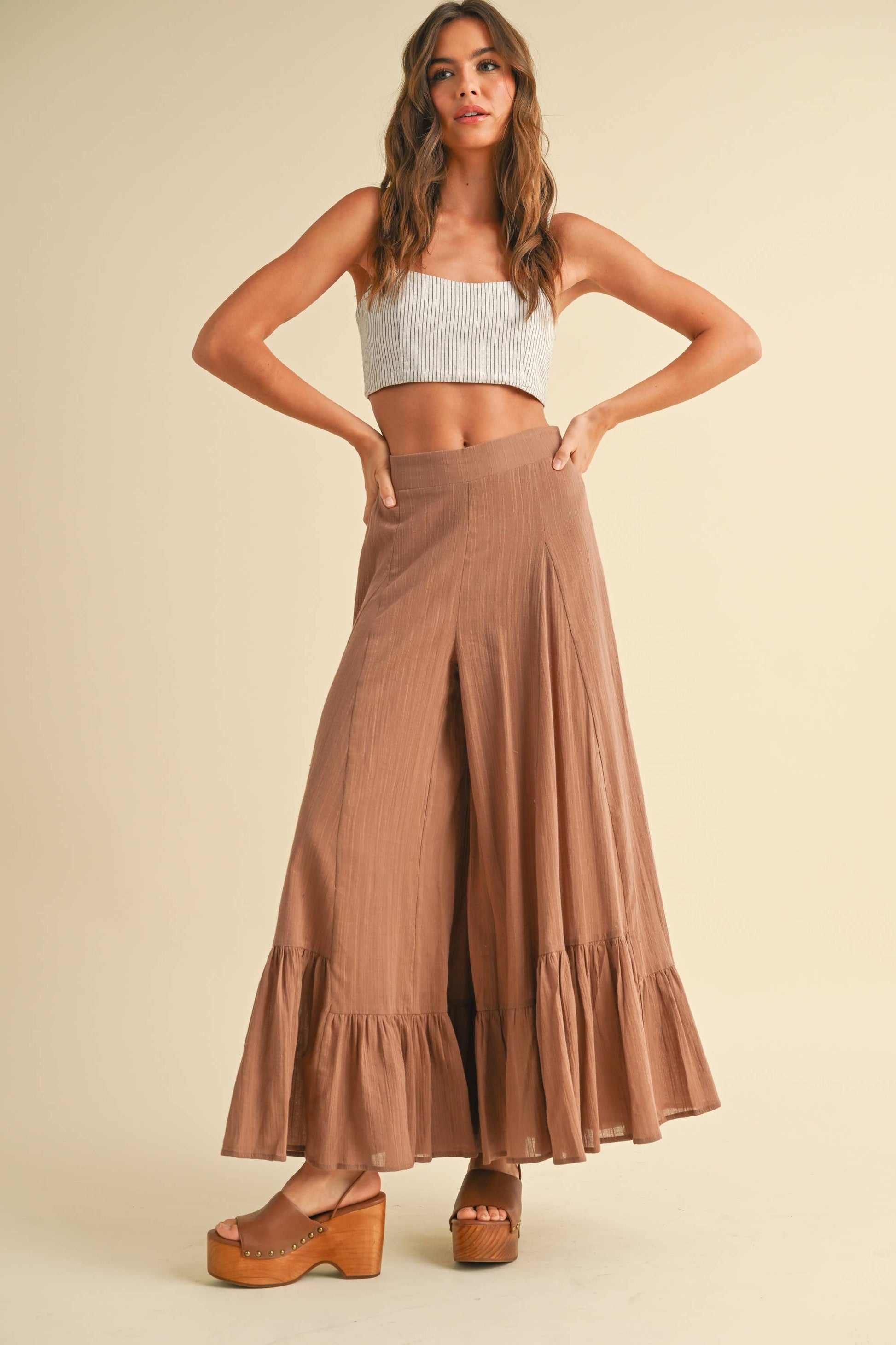 Bequeme und elegante, weite Hose in Braun mit Rüschenbesatz am Saum – 100 % Baumwolle für ein luftiges Gefühl an warmen Tagen.