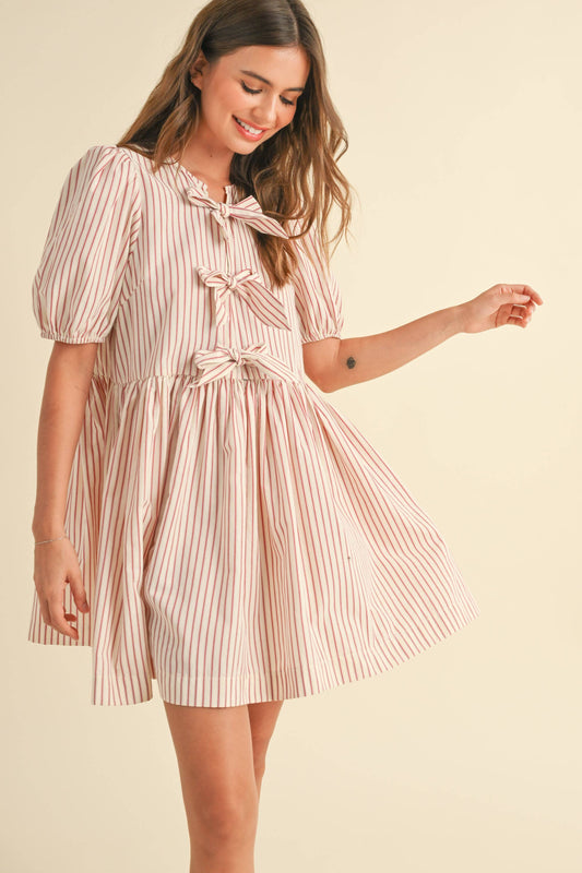 Gestreiftes Kleid mit Schleifendetails vorne – Ein elegantes Kleid mit modernen Streifen und verspielten Schleifen an der Vorderseite für einen femininen Look.