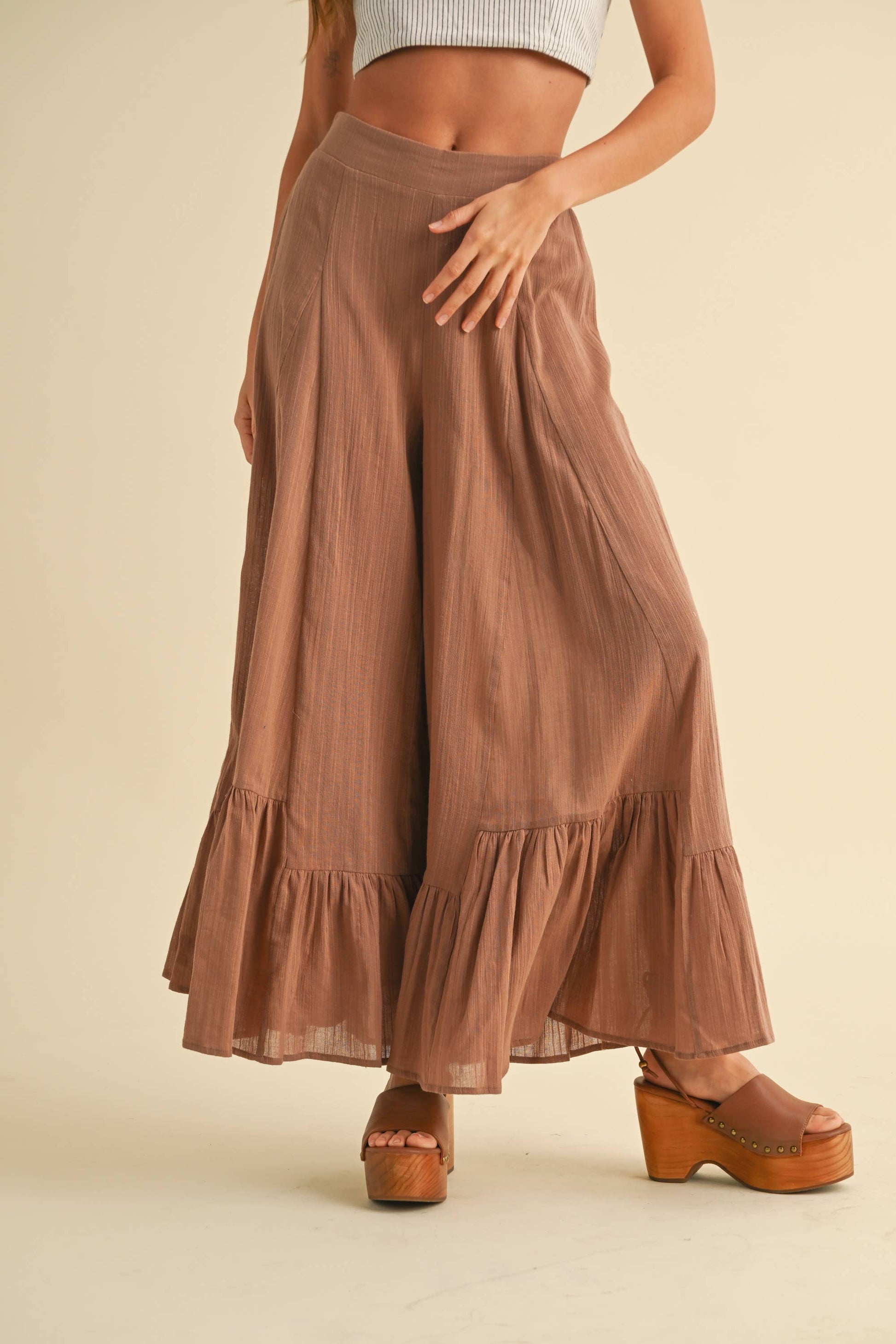 Die weite braune Hose mit Rüschen am Saum aus 100 % Baumwolle sorgt für einen lockeren, femininen Look – Ideal für Freizeit und Sommerausflüge.